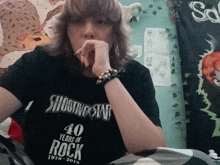 a woman wearing a shooting star 40 years of rock shirt