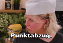 a woman wearing a chef 's hat says punktabzug in white letters