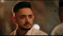 a man with a beard is looking at himself in the mirror .