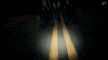 a blurry picture of a person walking down a street with a flashlight .