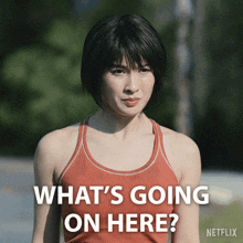 a woman in a red tank top with the words what 's going on here