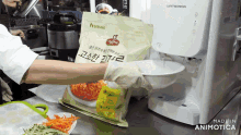 a person holding a bag of food in front of a water dispenser
