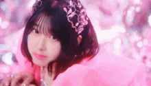a girl wearing a pink dress and a tiara