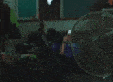 a man in a purple shirt is looking at his phone