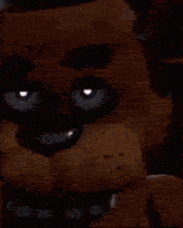 a close up of a teddy bear covering his mouth with his hand .
