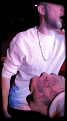 a man wearing a white shirt and a chain around his neck