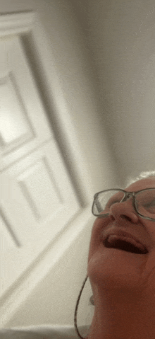 a woman wearing glasses and hoop earrings is smiling