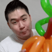 a man is holding a bunch of balloons in his hands and making a funny face .