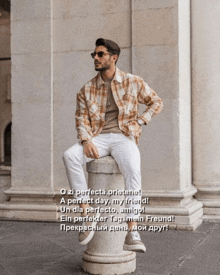 a man in a plaid shirt is sitting on a stone post