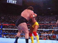 two wrestlers are wrestling in a ring with the word event behind them