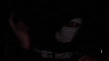a man wearing a mask and a hoodie with the word nc on it .