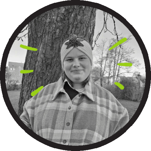 a black and white photo of a woman in a plaid shirt standing next to a tree