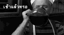 a black and white photo of a man drinking a cup of coffee from a bowl .