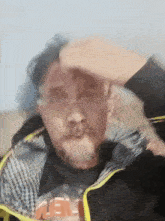 a man with a beard wearing a black shirt that says ' uee ' on it