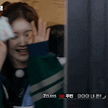 a woman in a green sweater with zclass written on the bottom right
