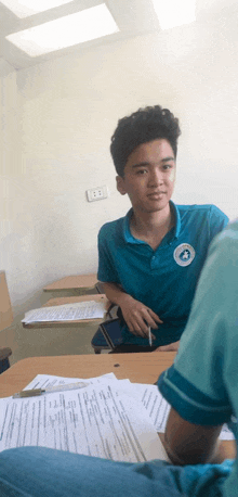 a boy wearing a blue shirt with a badge that says ' saigon ' on it