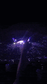 fireworks are displayed over a large crowd of people at a concert