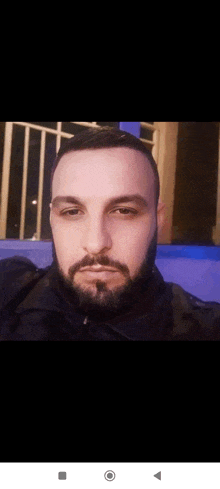 a man with a beard is taking a selfie