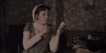 a woman sitting at a table holding a book