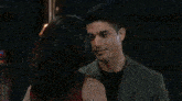 a man and a woman are kissing in a room .