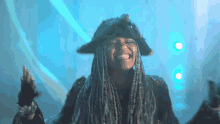 a woman wearing a pirate hat and dreadlocks is smiling