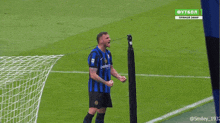 a soccer player wearing a blue and black jersey that says bet365