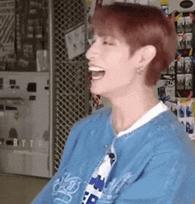 a man in a blue shirt is laughing in a room .