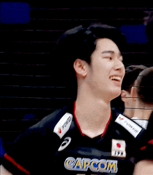 a man wearing a capcom jersey with the number 15