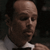 a man with a mustache is wearing a white shirt and a bow tie