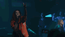 a woman with long hair singing into a microphone