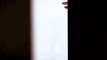 a person with a tattoo on their finger is holding a black object in their hand .