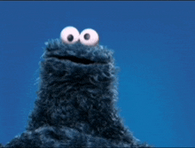cookie monster from sesame street waving his hand in the air