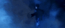 a man in a suit is flying through the air in a blue light .