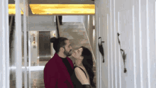 a man and a woman are standing next to each other in a hallway