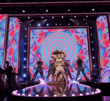 a woman stands on a stage in front of a large screen that says ' a ' on it