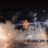 a man standing in front of a fireworks display at night