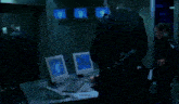 a man is typing on a keyboard while a woman watches