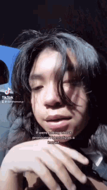 a young man with long hair is sitting in a car and talking to someone .