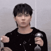 a young man is making a funny face while holding a dumbbell in his hand .