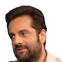 a man with a beard wearing a white shirt looks at the camera