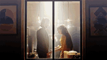 a man and woman are looking at each other through a glass door