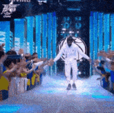 a basketball player is walking on a stage in front of a crowd at an all star game