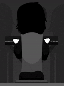 a silhouette of a person sitting at a keyboard