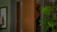 a man in a suit stands in a doorway looking out