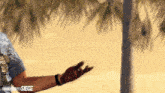 a man wearing a rainbow six siege shirt reaches out his hand