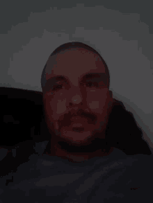 a close up of a man 's face with a beard in the dark
