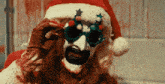 a bloody clown wearing a santa hat and glasses with stars on them