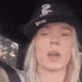 a woman wearing a black hat with a white letter r on it