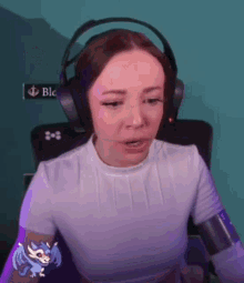 a woman wearing headphones and a white shirt is sitting in front of a computer .