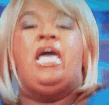 a woman with blonde hair is making a funny face with her mouth open